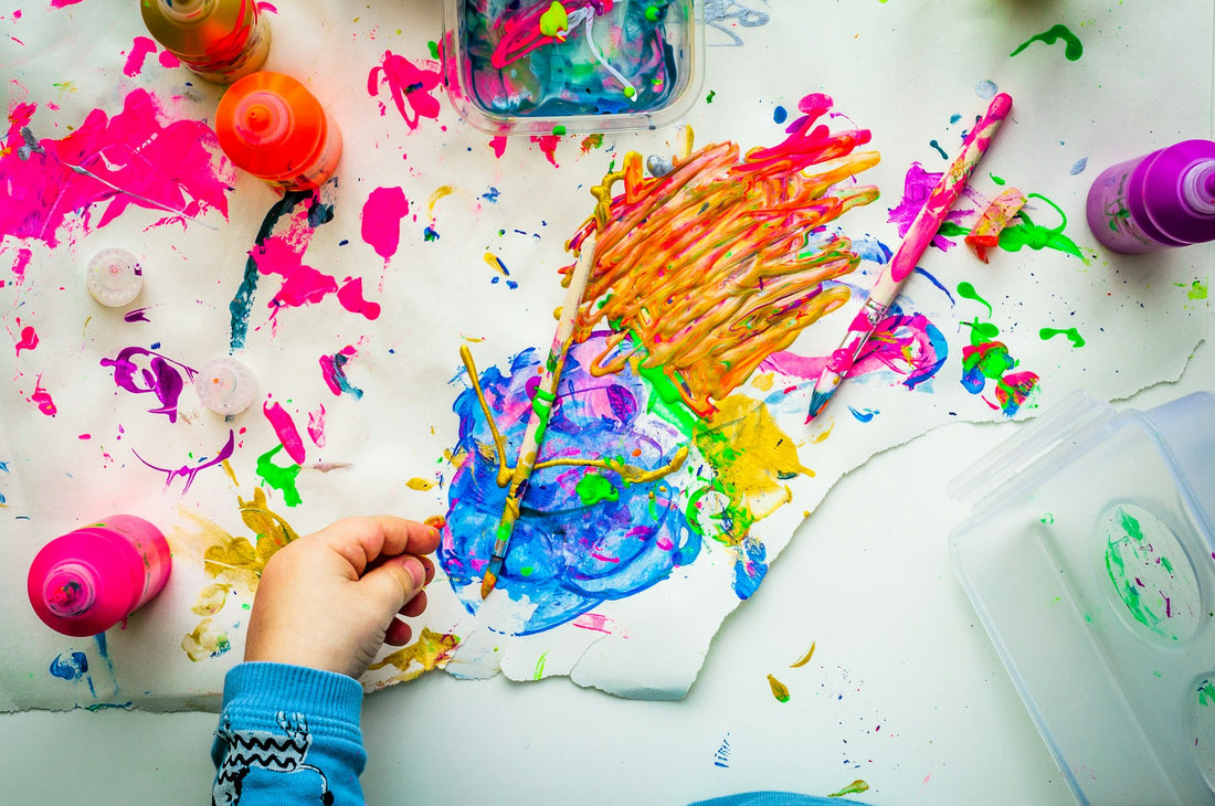 A child creating art with some kid-friendly art supplies.