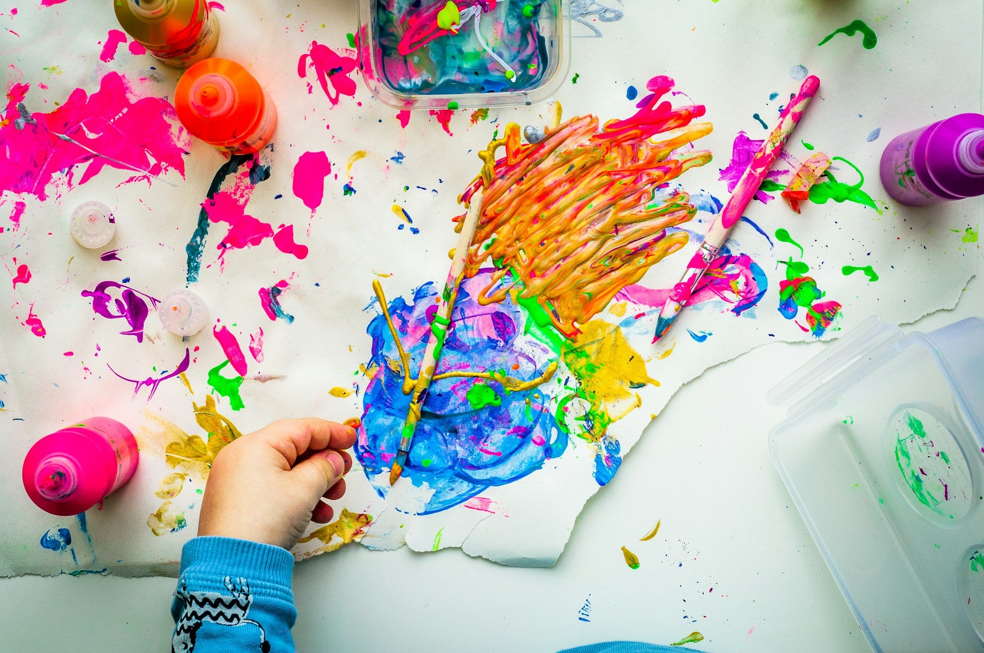 A child creating art with some kid-friendly art supplies.